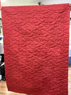 Red quilted blanket hanging indoors